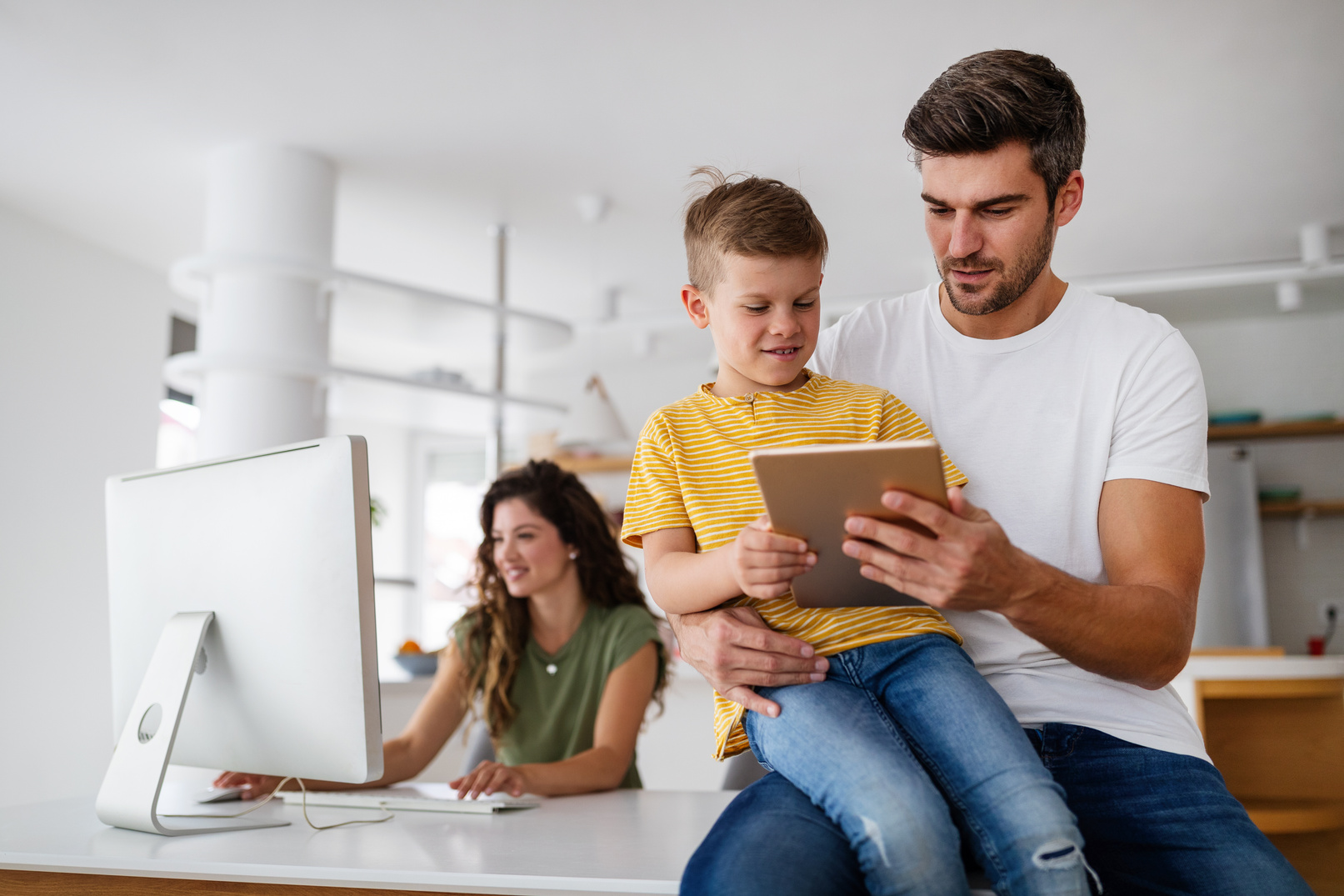 Happy family using technology devices together at home.